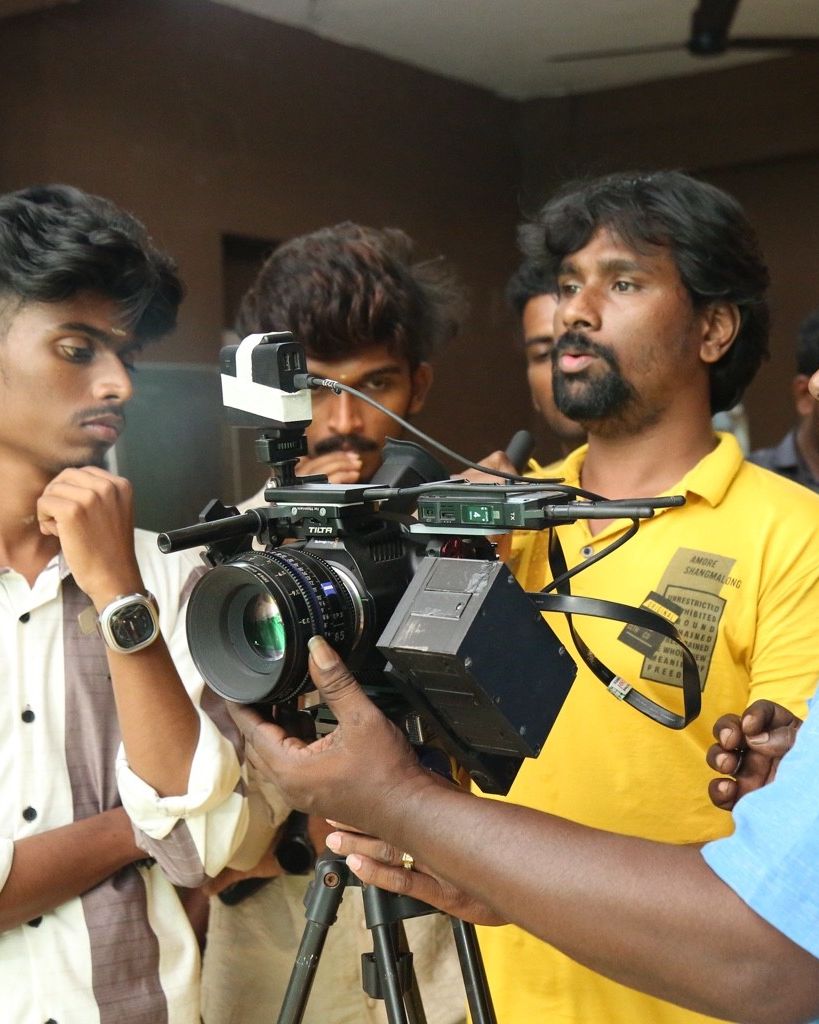 Crew checking a cinema camera on the Treyfa set